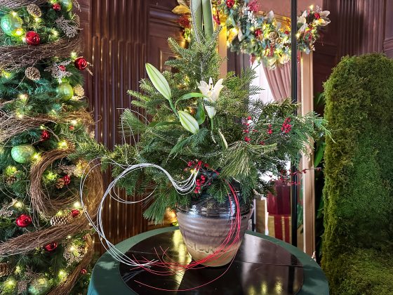 a holiday floral arrangement in a silver vase
